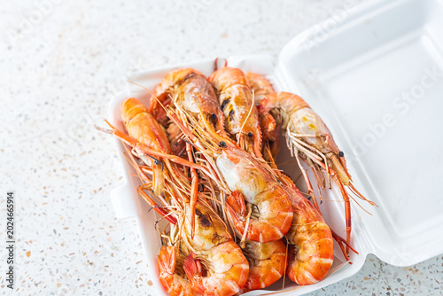 Photos Grilled shrimps on a Styrofoam box.