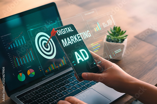 Digital marketing ad displayed on smartphone with charts and graph on laptop.