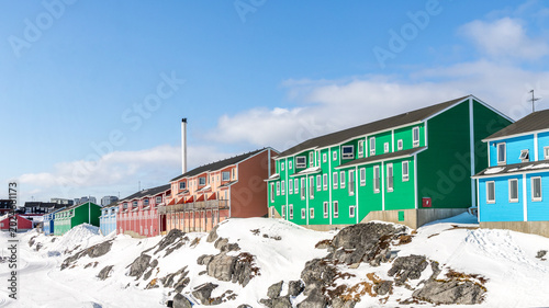 Schilderij op canvas Bright green and blue Inuit houses above snow-covered rocks in a winter neighbor