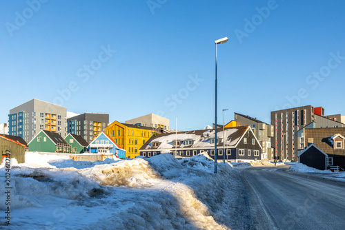 Foto Modern Inuit neighborhood with colorful wooden houses, apartment blocks and snow