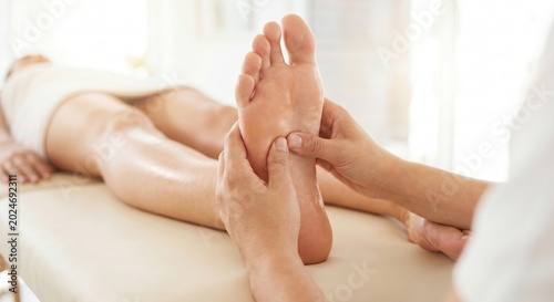 Therapist applying pressure during a reflexology foot massage
