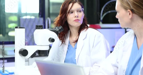  Scientist looking through a microscope in a laboratory