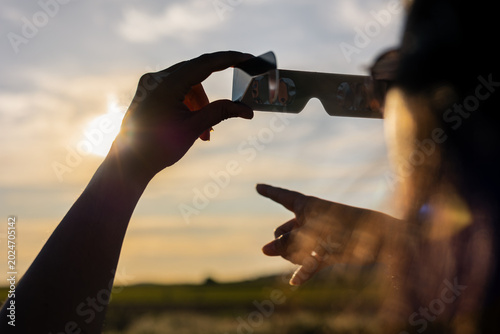 Konstfotografi Person observing astronomical event with cardboard solar eclipse glasses protect