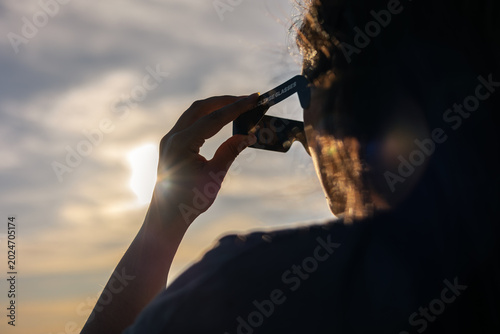 Canvastavla Person using solar eclipse glasses for safe total or annular solar observation,