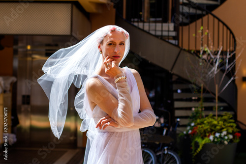 young attractive  homosexual man posing in bride's dress