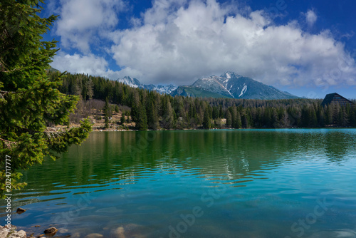 Scenic mountain lake reflection under blue sky. Štrbské Pleso High Tatras, Slovakia