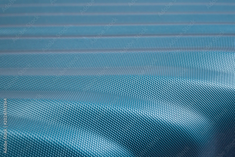 Fototapeta premium Waved turquoise carbon fiber plastic texture, surface detail close up , abstract patterned backdrop wallpaper