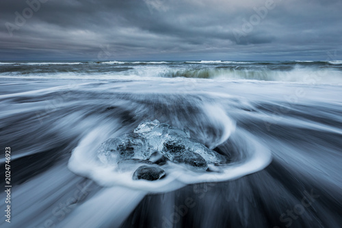 Bild auf Leinwand Sea waves hitting ice chunks in Fellsfjara (diamond beach) in Iceland