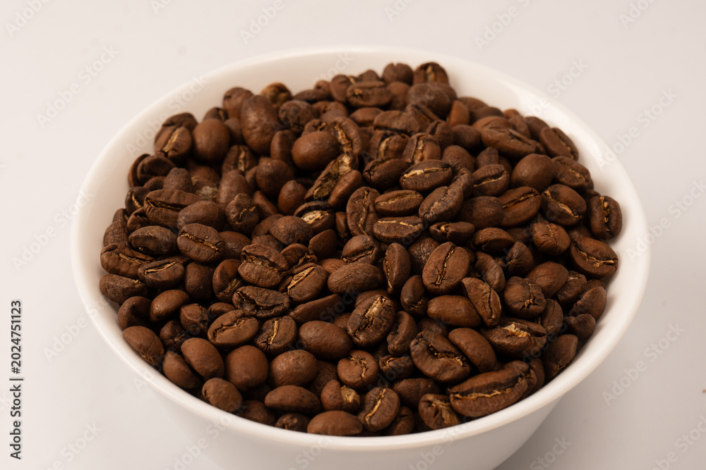 Fototapeta premium Coffee beans on a white background. Top view. Coffee beans texture.