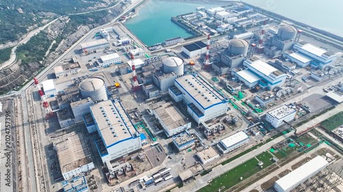 Coastal nuclear power plant with reactor domes and industrial buildings