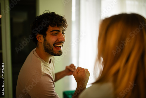 Foto Young man laughing and celebrating with a woman