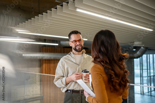 Employees communicating during coffee break in modern office