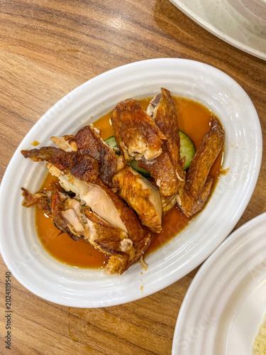 Photography Popular Hainanese fried chicken served in Bukit Bintang Kuala Lumpur, featuring crispy golden texture, rich savory sauce, and authentic Malaysian culinary atmosphere