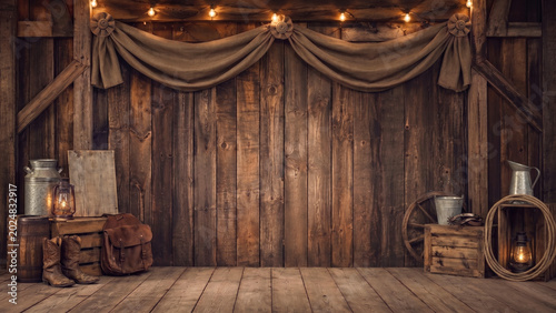 Old West studio backdrop with rustic wood wall, draped fabric, lanterns, boots, rope, wagon wheel and vintage props, leaving open center space for photography composites.