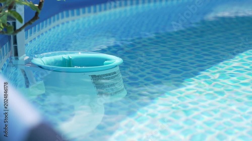 Floating Pool Skimmer in Clear Blue Backyard Swimming Pool
