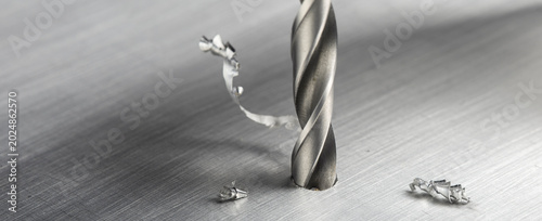 Foto drill bit make hole in metal aluminum plate with chip