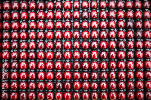 Red beads. Shiny wooden beads in a symmetrical arrangement. Full frame od texture. Background. Shape. Dot.