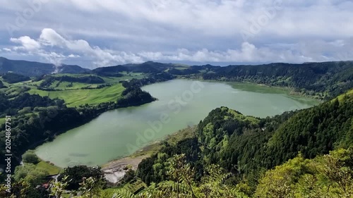 Panoramic green valley with large lake, forested slopes and dramatic clouds. Lagoa das Furnas isla Sao Miguel dos Açores