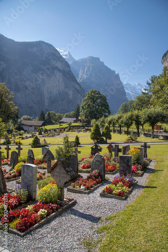 Lauterbrunnen valley cemetery with mountains and blooming flowers