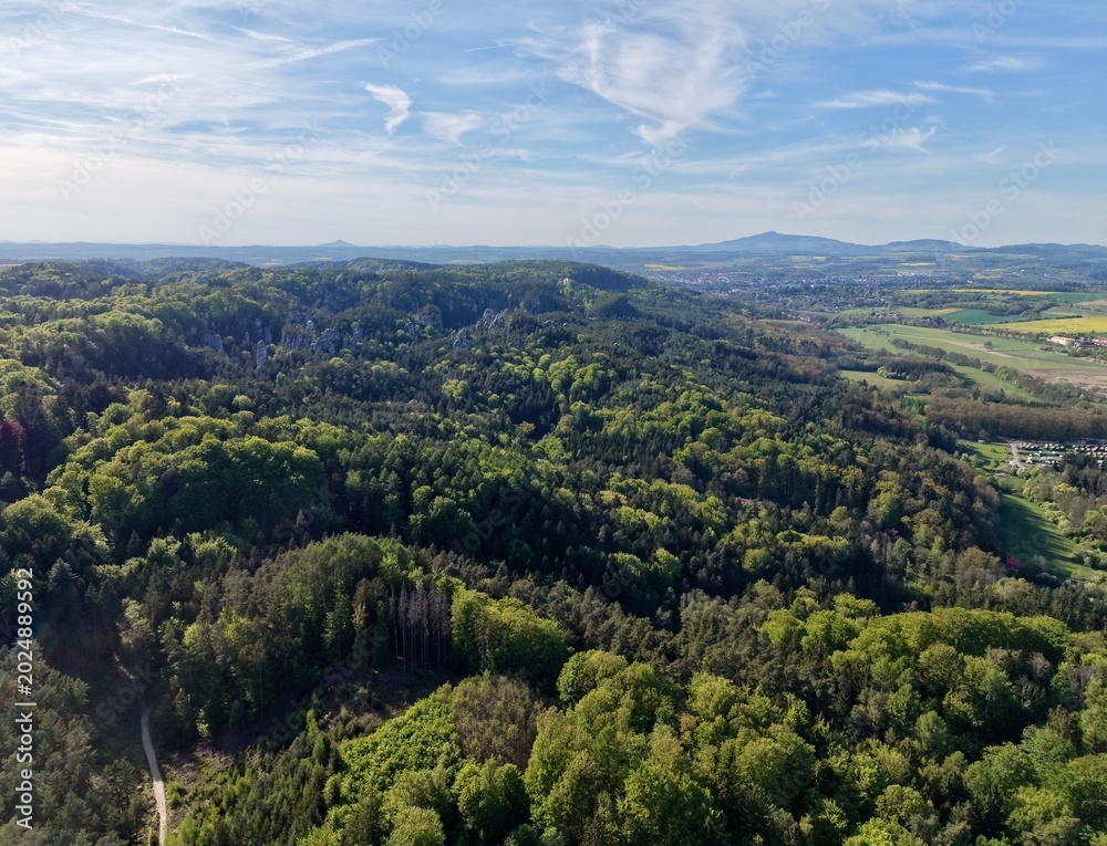 Obraz premium Wide green valley with mountains. Large green plains surrounded by distant peaks and curved pathways