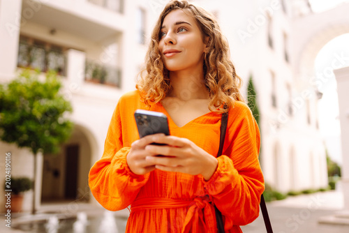 Foto A woman stands on a city street wearing an orange dress