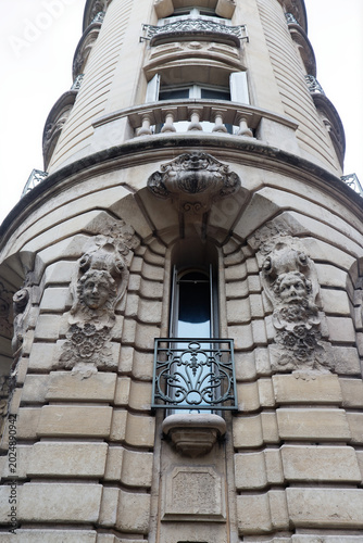 Dramatic low-angle view of a rounded corner tower on a classical Parisian building