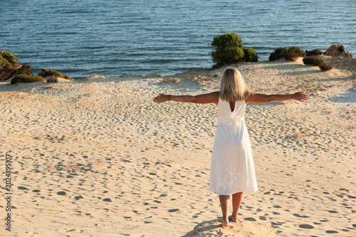 Mujer joven meditando en la playa.