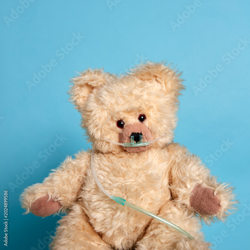 A teddy bear with an oxygen tube over its face, symbolising medical care for children and adults