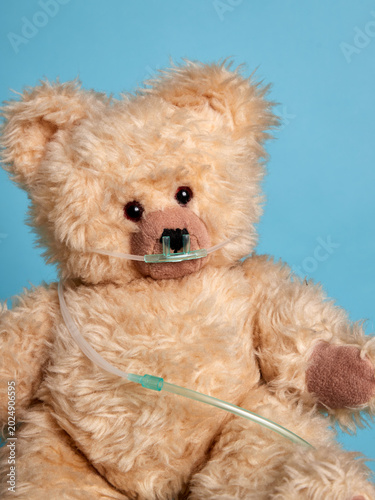 A teddy bear with an oxygen tube over its face, symbolising medical care for children and adults