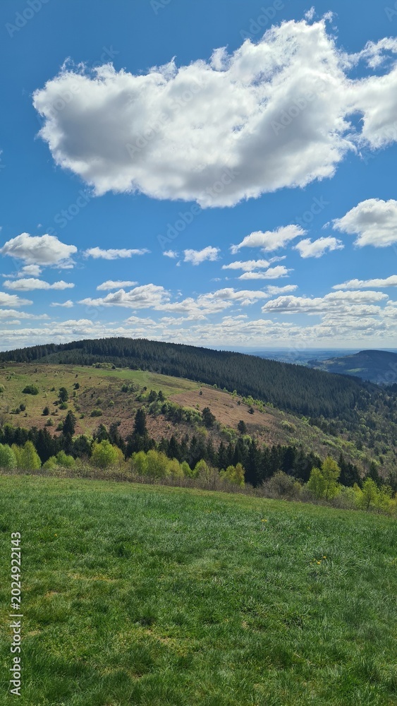 Fototapeta premium La Montagne limousine (avec le Plomb du Cantal en arrière-plan) vue depuis le sommet du Suc au May un bel après-midi de printemps (Limousin)