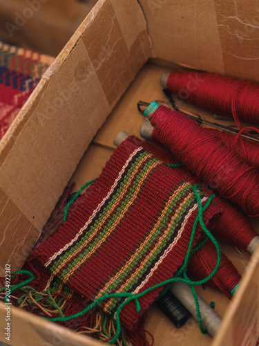 Konstfotografi Artisan hands weaving traditional ethnic beaded jewelry on a small manual wooden handicraft loom