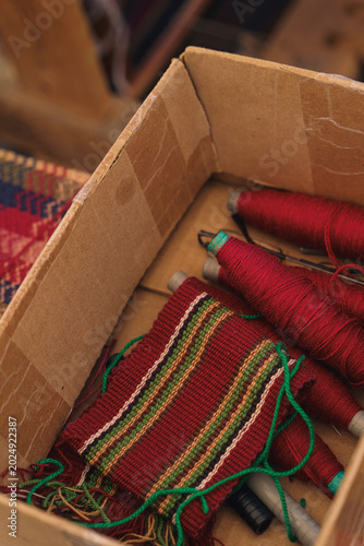 Konstfotografi Artisan hands weaving traditional ethnic beaded jewelry on a small manual wooden handicraft loom