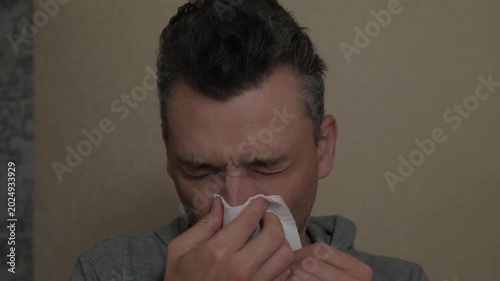 Closeup of sick man. Man showing signs of illness up close. Close examination of fatigued man with cold symptoms. Detailed depiction of unwell man with watery eyes and nasal congestion at home
