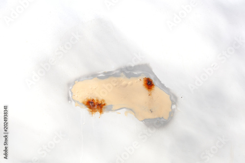 Fotografie A close-up of a white car part with a filled hole and exposed rust on the metal