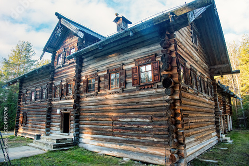 Foto Large historic log house exterior in sunlight