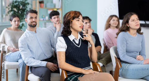Bild auf Leinwand Interested male and female students sitting together and listening the lesson at
