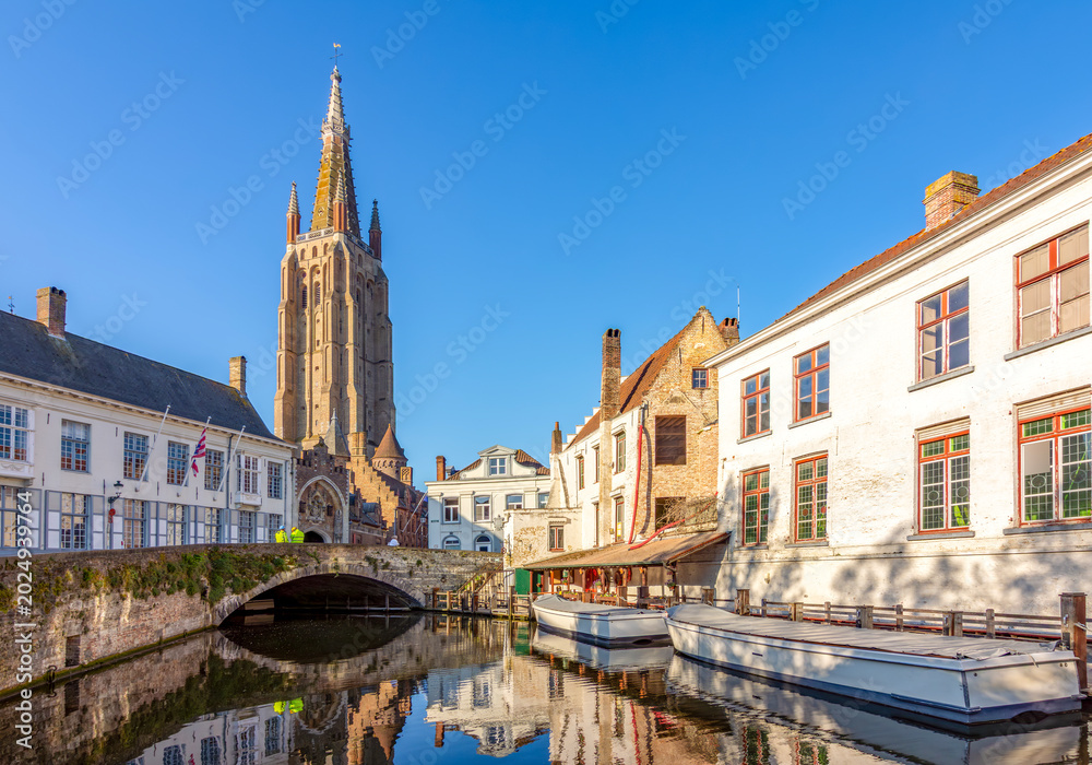 Fototapeta premium Church of our Lady tower and Dijver canal in Brugge, Belgium