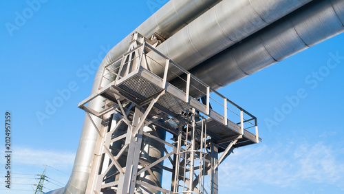 A close-up of a pipeline with a blue sky in the background