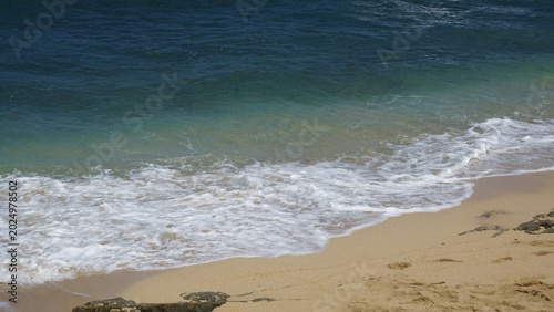 Vászonkép waves on the beach with yellow sand in evening