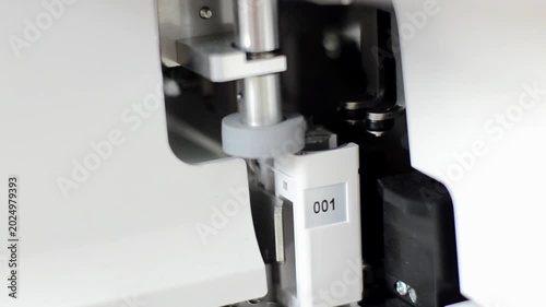 Close up of a precise laboratory automated sampling machine nozzle needle mechanism inside medical diagnostic equipment