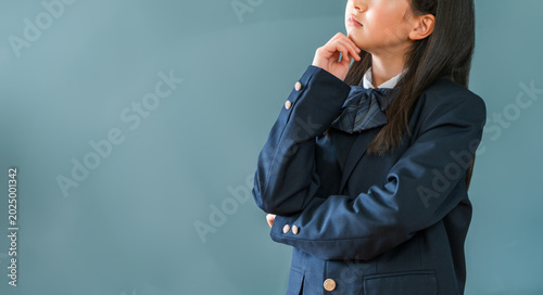 Foto 教室の黒板の前で考える,悩む制服姿の小学生,中学生,高校生の女の子