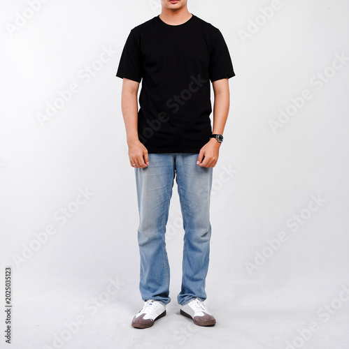 Male body wearing black t-shirt and blue jeans seen from behind and isolated on white background