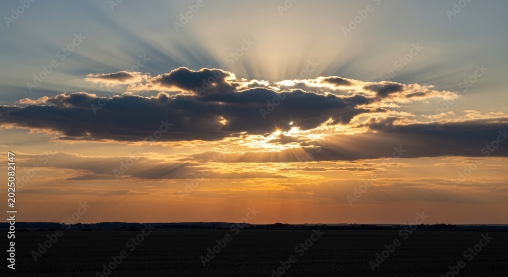 Fototapeta premium Golden sunset with bright sun rays breaking through dark clouds over flat horizon, for hope divine inspiration while for new beginning spiritual peace mind