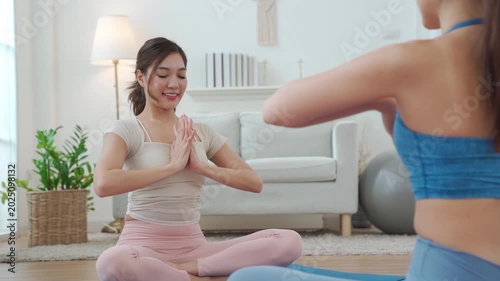 Asian women doing shoulder stretch pose during yoga at home