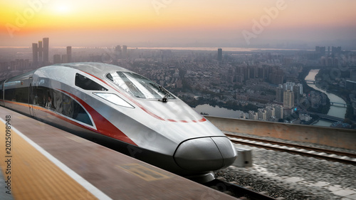 High speed bullet train stopped at urban railway station at sunset