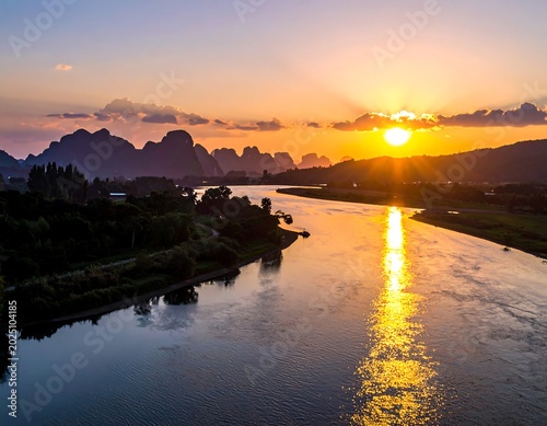 Golden Sunset Reflecting on Calm River Between Mountain Silhouettes