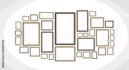 Arrangement of various sized empty picture frames in wooden tones mounted on a light gray wall creating a gallery wall layout.
