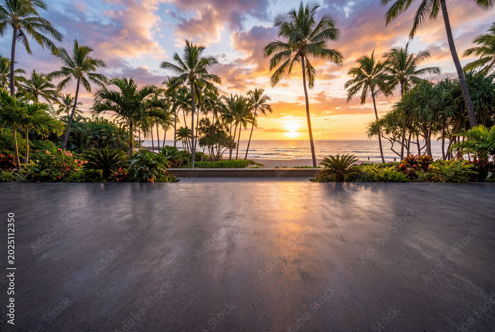 Fototapeta premium Empty dark grey concrete floor foreground against tropical beach sunset with tall palm trees