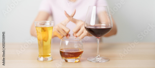 Photos woman stop hand gesture to refuse a glass of wine, beer, whiskey or cognac on table