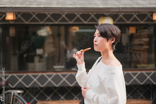 Foto 伝統的な観光地で食べ歩きをする女性